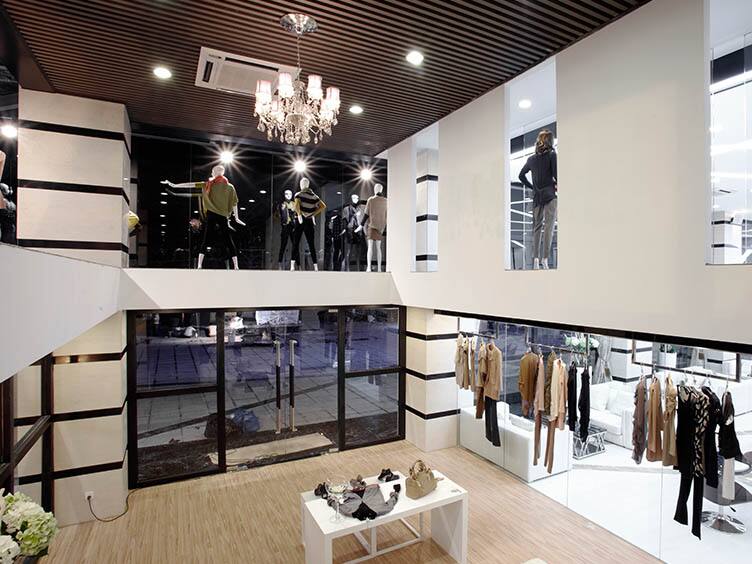 Interior of a mall, with clothing stores in view
