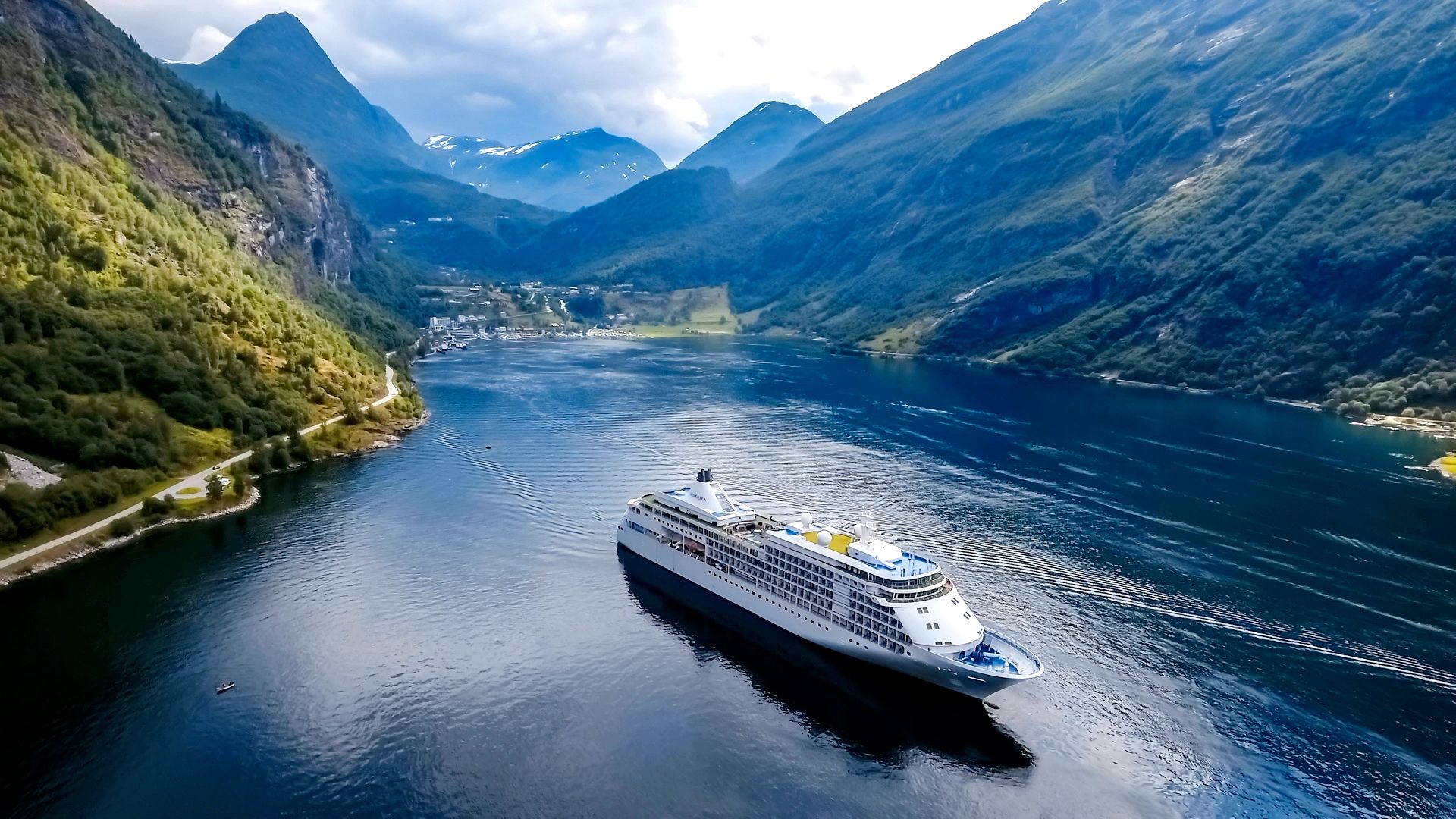 Cruise ships sailing through a mountain fjord.
