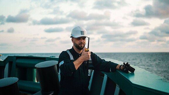 An employee talking to walkie talkie on a ships