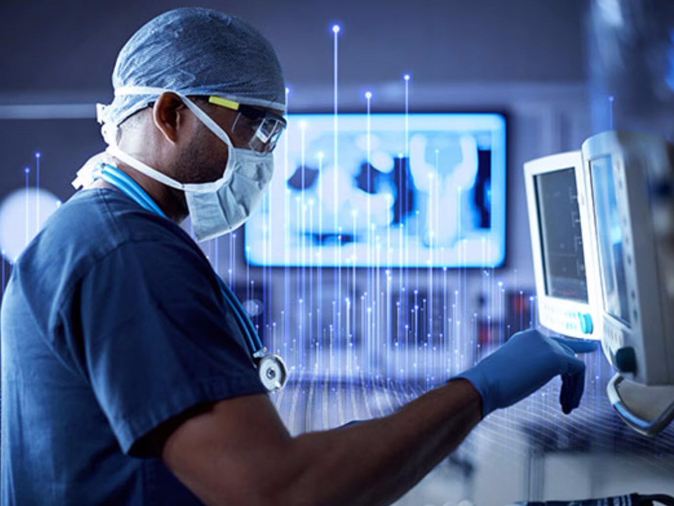 Medical staff in scrubs checking a monitoring device in a hospital room